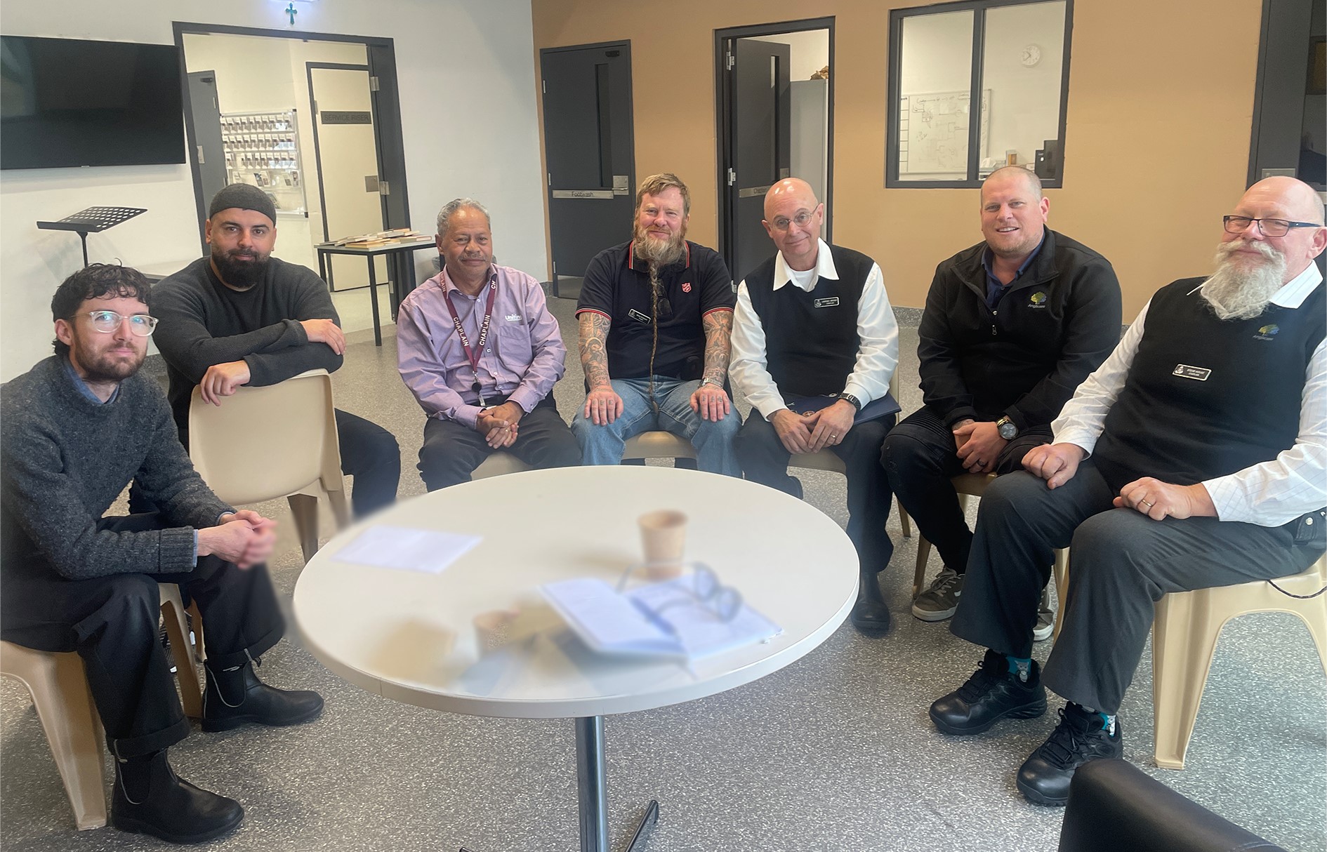 Group of 7 men sitting at a table